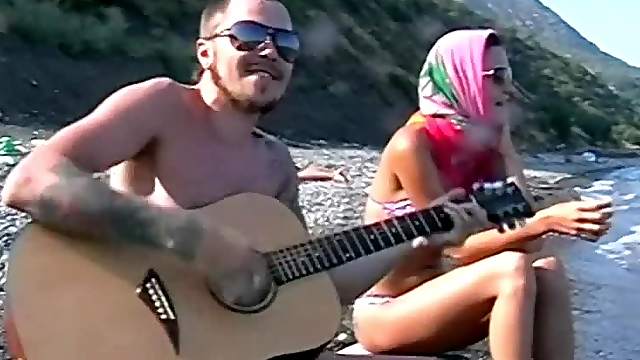 He plays guitar for her and fucks her on the beach