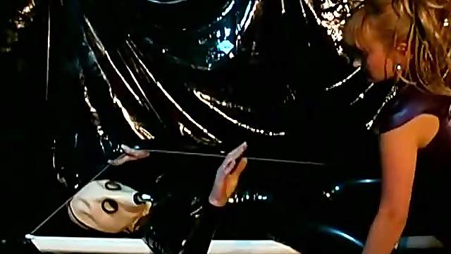 Latex Slave Suspended From The Ceiling