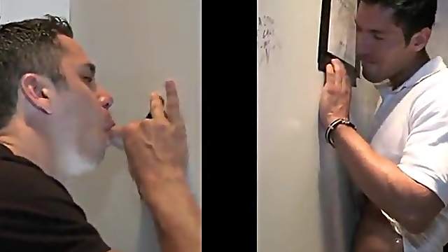 Captivating gay in t-shirt enjoying being given blowjob through gloryhole