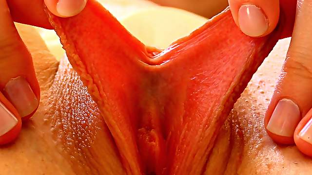 She uses two fingers to pry her pink pussy wide open