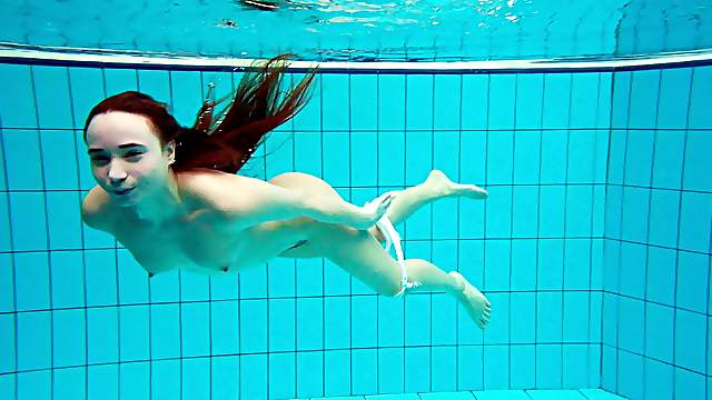 Russian redhead teen with small tits dives deep in the pool