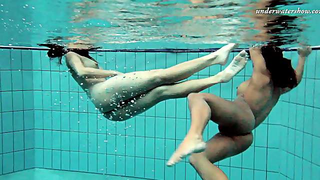 Two delicious hotties enjoy swimming in the pool while being naked