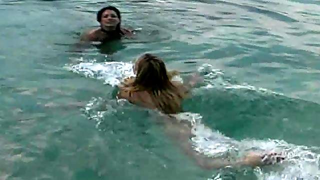 Two seductive charmers enjoy sharing a massive dick at the beach