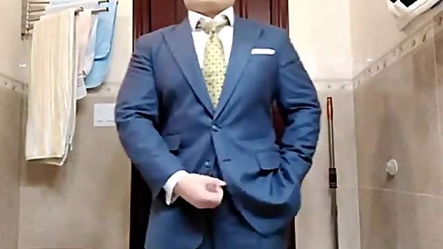 Сheerful business man fingering in a suit in front of a mirror