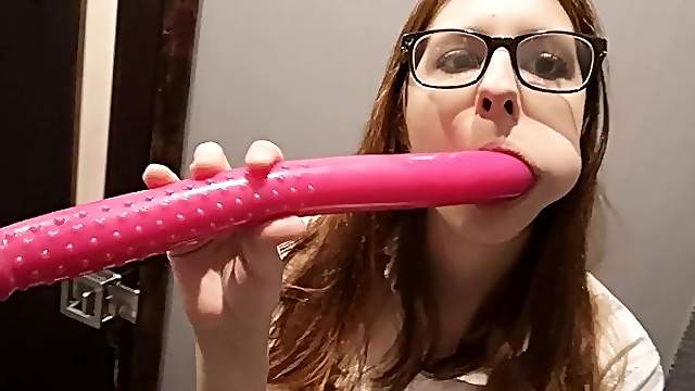 Lady with glasses plays with a dildo.
