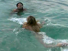 Two seductive charmers enjoy sharing a massive dick at the beach